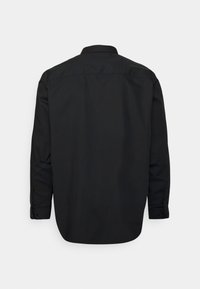 Zwarte langwerpige shirt met lange mouwen, voorzien van een klassieke kraag, knopenmanchetten en een gladde textuur, met een rechte snit en zonder zichtbare patronen.