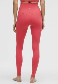 Hooggesneden roze leggings van rekbare stof, met een naadloos ontwerp en een logo bij de tailleband. Gladde textuur en aansluitende pasvorm.
