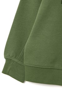 Close-up van groene sweatshirtstof die een gladde textuur toont, met ribgebreide manchetten en naden. Geen patronen of versieringen zichtbaar.