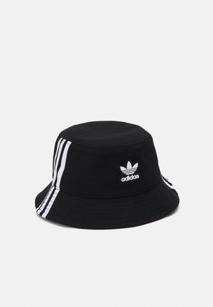 Bob noir Adidas avec trois bandes blanches sur les côtés et logo trèfle Adidas à l'avant.