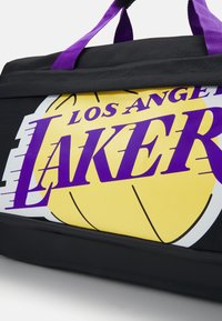Fekete sporttáska sárga baseball grafikával, lila szöveggel "LOS ANGELES LAKERS" és lila füllel. Tartós anyag, texturált felülettel.
