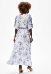 Lang bloemenjurk met blauw-witte patronen, korte mouwen en een getailleerde taille. Glad stof met een vloeiende, relaxte silhouet.