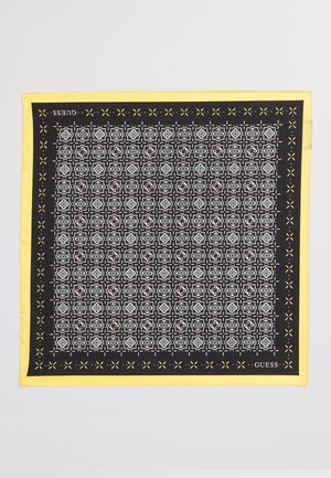 Zwarte sjaal met gele rand, met een herhalend wit geometrisch bloemmotief en kleine "Guess" logo's in twee hoeken.