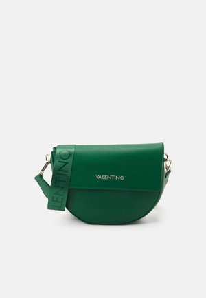 Bolso cruzado Valentino en forma de media luna verde con cierre de solapa y una correa ancha verde con texto Valentino en relieve.