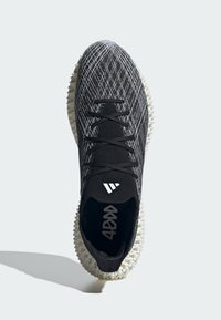 Black athletic shoe with a textured upper featuring a grid pattern, white accents, and a distinctive white, spiked sole design.