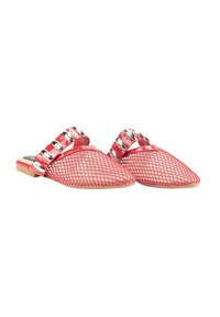 Zapatillas rojas de malla sin cordones con punta afilada, que presentan acentos metálicos y una suela plana. El diseño incluye una cinta decorativa con herrajes circulares.