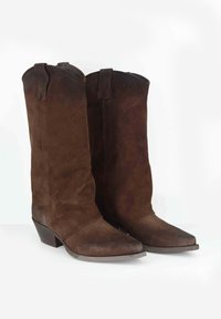 Stivali da cowboy in suede marrone con punta affusolata e tacco medio. Presentano linguette superiori per indossarli facilmente. Finitura strutturata su tutta la superficie.