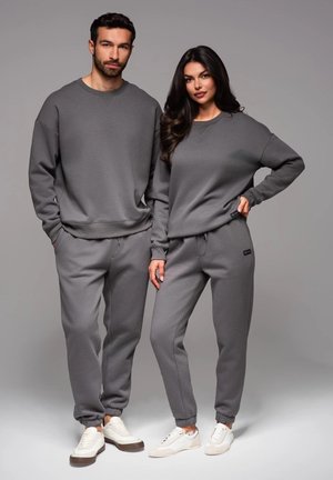 Conjunto de sudadera y pantalones de chándal gris para hombres y mujeres, con un ajuste relajado, puños acanalados y una textura de tela suave. Diseño clásico.