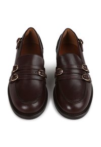 Brown leather loafers with dual straps and metal buckles, rounded toe, smooth texture, and contrast stitching on the vamp.