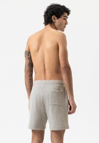 Shorts en coton gris avec taille élastique, longueur mi-cuisse et une poche arrière. Texture douce et design simple, adaptés pour un usage décontracté.