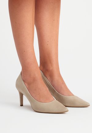 Beige mokkasiner med høye hæler, spiss tådesign og slank stiletthæl, som viser en jevn tekstur og minimalistisk stil.