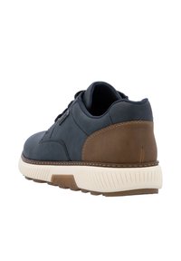 Zapatillas para hombre con parte superior de cuero azul marino, acento de cuero marrón y suela de goma blanca. Presenta detalles texturizados y un collar acolchado.