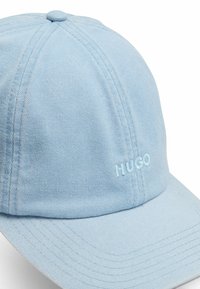 Helleblaue Baseballmütze aus Baumwolle mit vertikaler Rippstruktur. Mit gesticktem "HUGO"-Logo in passender Farbe. Gebogener Schirm.
