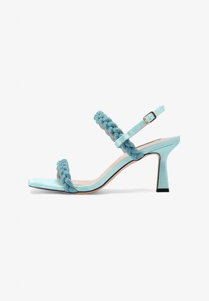 Sandal alto in satin aqua con cinturino intrecciato, punta aperta e fibbia alla caviglia. Presenta un elegante tacco a spillo e una suola nera a contrasto.