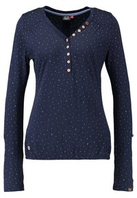 Mörkblå långärmad skjorta med små ljusa stjärnmönster, V-ringning och sex träknappar längs framsidan och axelsömmen.