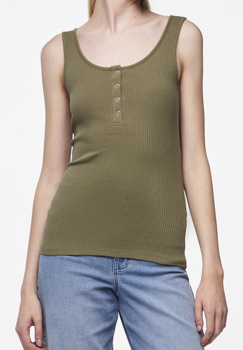 Olivgrön ribbad tanktop med rundad halsringning och fem knappar framtill. Parat med ljusblå jeans.