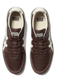 Pair of brown and white Onitsuka Tiger sneakers with laces, perforated toe area, and branded tongue, viewed from above on a white background.