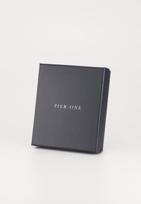 Boîte en carton noir avec une fermeture magnétique, portant le texte "PIER • ONE" embossé en blanc sur le devant, finition mate lisse, forme carrée.
