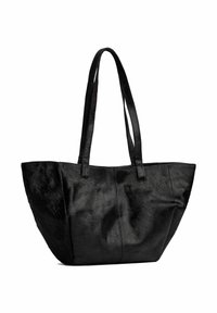 Fekete vászontáska puha, texturált anyagból, két hosszú fogantyúval és széles, strukturált formával. Nincsenek látható fém alkatrészek vagy díszítések.