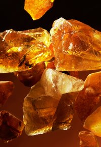 Bärnsten i olika former som visar rika gyllene nyanser, genomskinliga kvaliteter och distinkta texturer med sporadiska inklusioner.