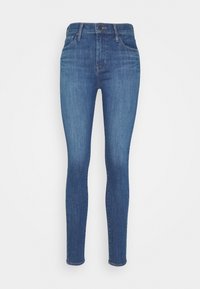 Jean skinny en denim bleu, avec une taille haute, cinq poches et une coupe classique ajustée. Texture lisse avec un léger effet délavé.