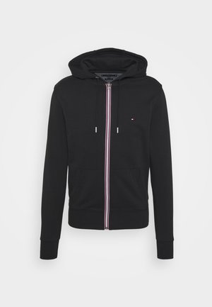 Sweat à capuche noir avec fermeture éclair, poches frontales, capuche avec cordon de serrage, et petit logo rouge, blanc et bleu sur la poitrine gauche.
