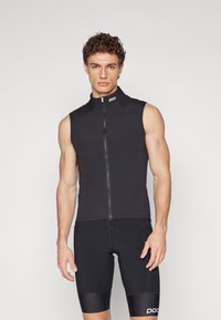 Gilet de cyclisme sans manches noir avec un col montant et une fermeture éclair à l'avant. Fabriqué en tissu lisse et extensible, avec le logo sur le col.