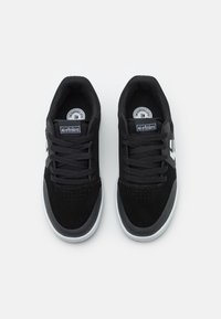 Μαύρα sneakers από σουέτ και πλέγμα, με στρογγυλή μύτη, επίπεδες κορδόνες και λευκό λογότυπο στο πλάι.