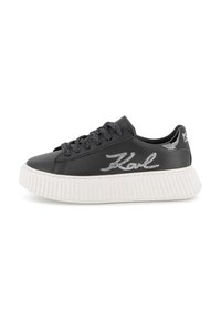 Black faux leather sneaker with textured white rubber sole, silver laces, and embroidered logo detail on the side.