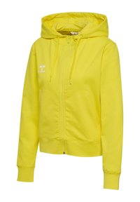 Haut zippé jaune en tissu doux. Doté d'une capuche, de poches kangourou et de poignets côtelés. Marque visible en blanc à l'avant.