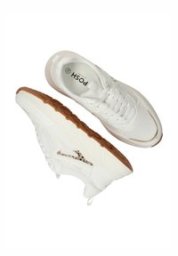 Witte sportieve schoenen met een textuur van gaas bovenwerk, een bruine rubberen zool en accenten van een luipaardprintontwerp aan de zijkant.