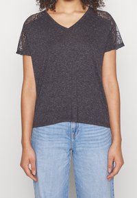 Camiseta gris oscuro de cuello en V con mangas cortas y detalles de encaje. Tejido suave con un ajuste relajado, complementada con un dobladillo recto.
