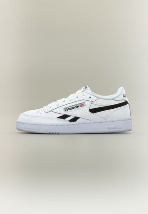 Бял нисък модел маратонки Reebok с черни ленти, лого, връзки и текстурирана подметка на едноцветен светлосив фон.