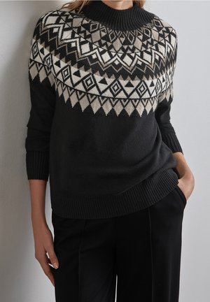 Pull noir avec un col montant et un motif géométrique crème et brun clair sur la poitrine, avec des bords côtelés aux poignets et à l'ourlet.