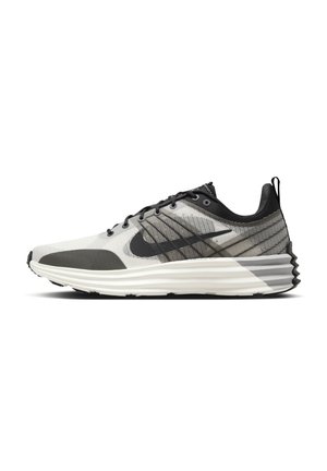 Lysegrå og sort atletisk løbesko med hvid lagdelt sål og sort swoosh-logo på siden, vist i profil.