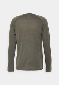 Langarmshirt in Olivgrün, aus weichem Stoff. Hat einen geraden Schnitt, Raglanärmel und eine zentrale Naht auf der Rückseite.