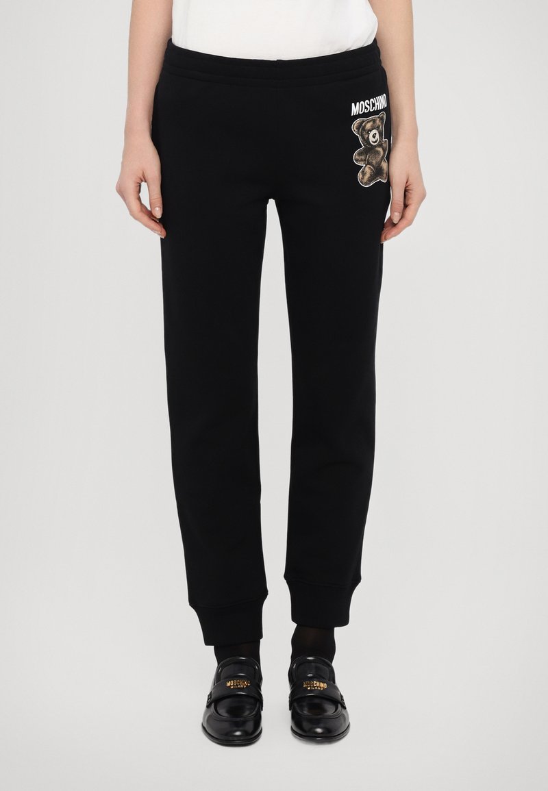 Zwarte sweatpants met een relaxte pasvorm, voorzien van een geborduurde beer graphic en merklogo op de linkse zak. Ribgebreide manchetten maken het ontwerp compleet.