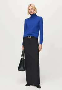 Maglione blu a collo alto, gonna maxi nera con cintura e borsa nera. Tessuto liscio con accenti minimi e silhouette aderente.