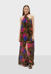 Vestido maxi con escote halter, patrones de flores y print de leopardo, abertura lateral, en colores vibrantes de rosa, azul y verde.