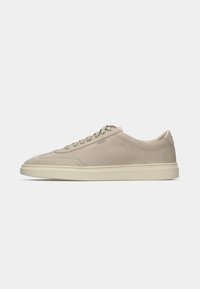 Beige suede lace-up sneaker with cream rubber sole and subtle stitching details, side embossed logo, and padded collar for comfort.