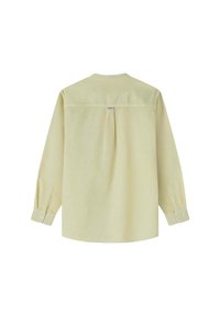 Camicia a maniche lunghe di un giallo chiaro con vestibilità rilassata, caratterizzata da una piega posteriore, polsini a bottone e un piccolo etichetta con logo vicino al collo.