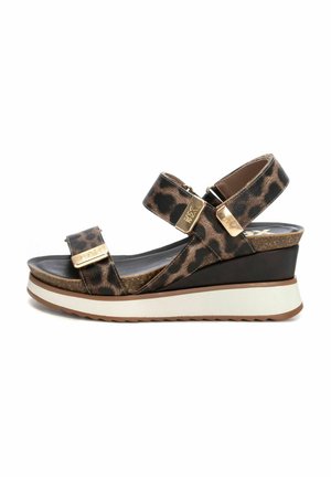 Sandalo con zeppa in stampa leopardata, design a doppia cinghia, accessori in tonalità oro e soletta imbottita. Presenta una suola piattaformata bianca testurizzata.