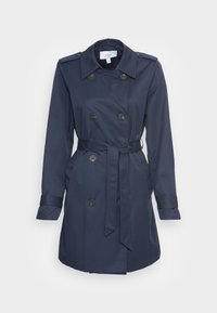 Trench-coat bleu marine en tissu lisse, doté de boutons croisés, d'une ceinture à la taille et de manches retroussées.