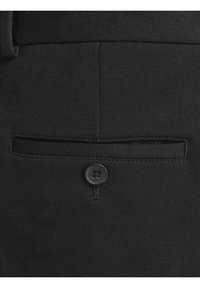 Svarta byxor med en bakficka med en sydd flik, säkrad med en rund svart knapp. Lätt textur med skräddarsydd passform.