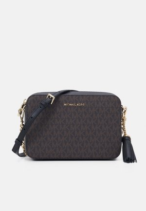 Rechthoekige donkerbruine Michael Kors crossbodytas met logopatroon, verstelbare zwarte riem, gouden hardware en zwarte kwast aan de zijkant.