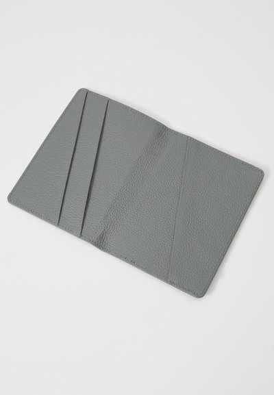 Intérieur de portefeuille en cuir gris avec trois emplacements pour cartes et finition texturée. Les bords lisses et le design minimaliste améliorent la fonctionnalité.