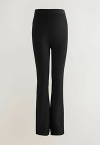 Schwarze gerippte Strickhose mit weitem Bein und elastischem Bund, aus einem strukturierten Stoff für Flexibilität und Komfort.