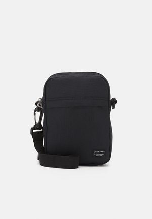 Lille sort crossbody taske med justerbar rem og forlommes lynlås, Jack & Jones mærke nederst til højre.