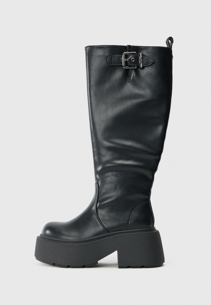 Crne kožne čizme do koljena s debelim platformom, koje imaju bočni zip, podešavajući detalj s kopčom i glatku teksturu.