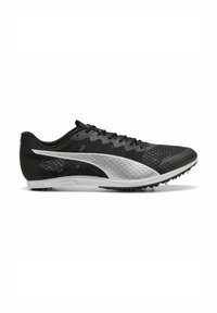 Zwarte sportieve schoen met een gestructureerde bovenkant, witte accenten, platte veters en een zool met spikes, ontworpen voor atletiekprestaties.